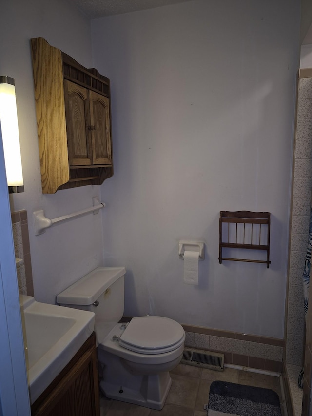 bathroom with tile patterned flooring, vanity, and toilet