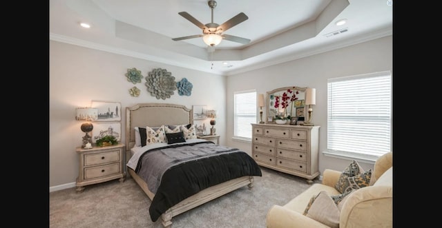 carpeted bedroom featuring a tray ceiling, crown molding, visible vents, ceiling fan, and baseboards