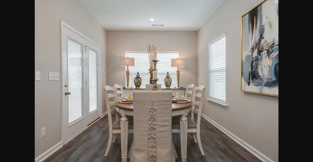 dining area with dark wood-style floors, visible vents, and baseboards