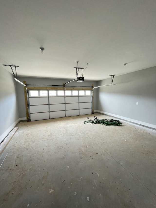 garage featuring a garage door opener and baseboards