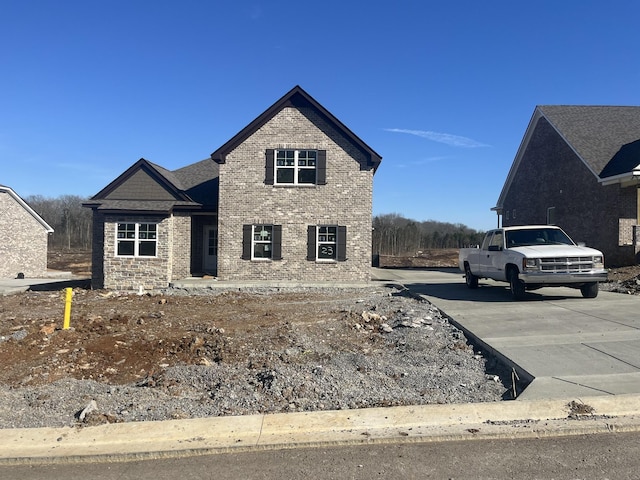 view of front of home with driveway and brick siding