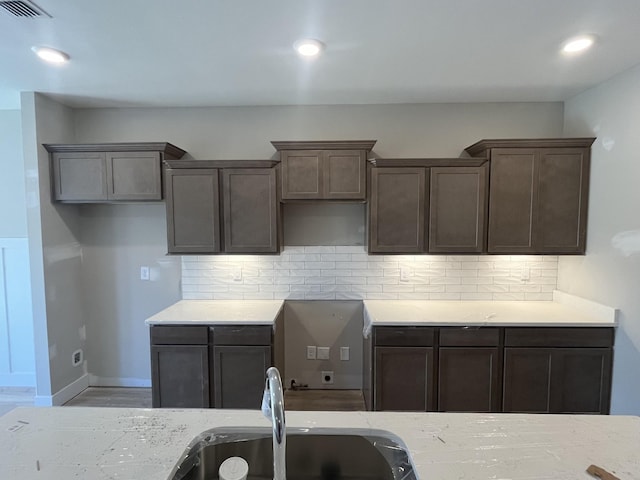 kitchen featuring dark brown cabinetry, recessed lighting, visible vents, baseboards, and tasteful backsplash