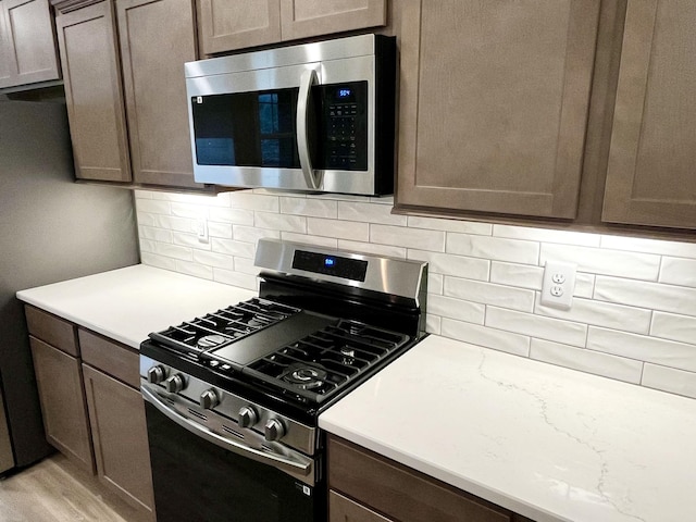 609 Spring Hill Dr, Smyrna, TN 37167 - kitchen with stainless steel appliances, decorative backsplash, light wood finished floors, and dark brown cabinetry