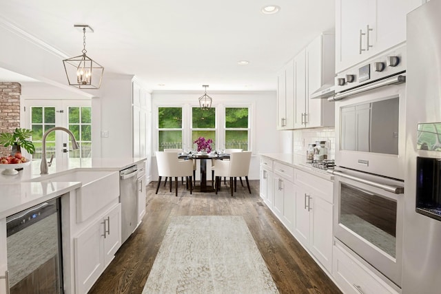 kitchen with a healthy amount of sunlight, white cabinetry, and stainless steel appliances