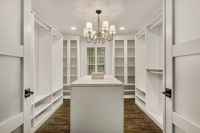 spacious closet featuring a chandelier and dark hardwood / wood-style floors