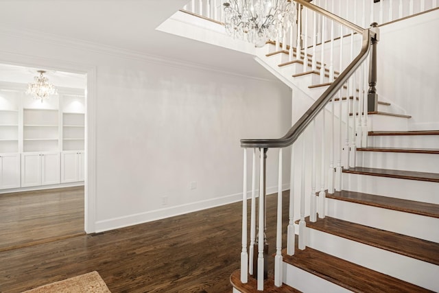 stairs with hardwood / wood-style flooring, crown molding, and a chandelier