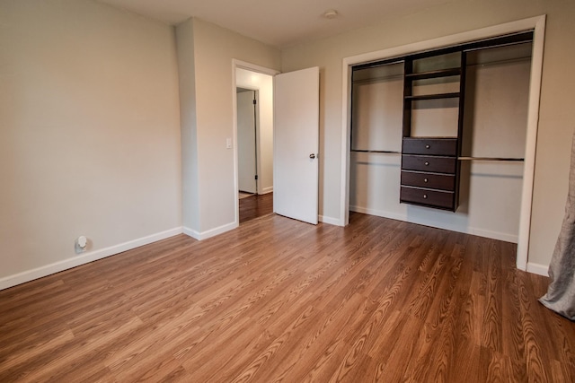 unfurnished bedroom with hardwood / wood-style floors and a closet