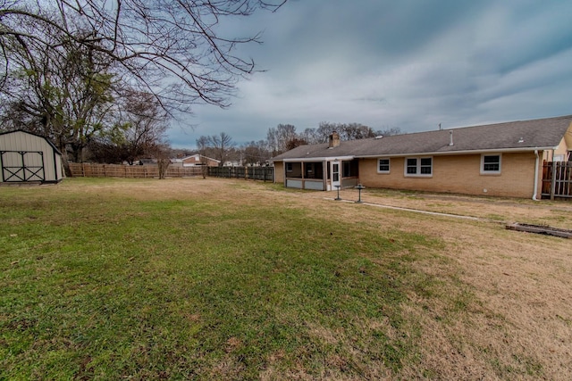 view of yard featuring a sunroom and a storage shed