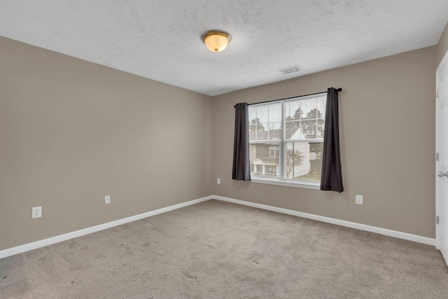 carpeted empty room featuring a textured ceiling