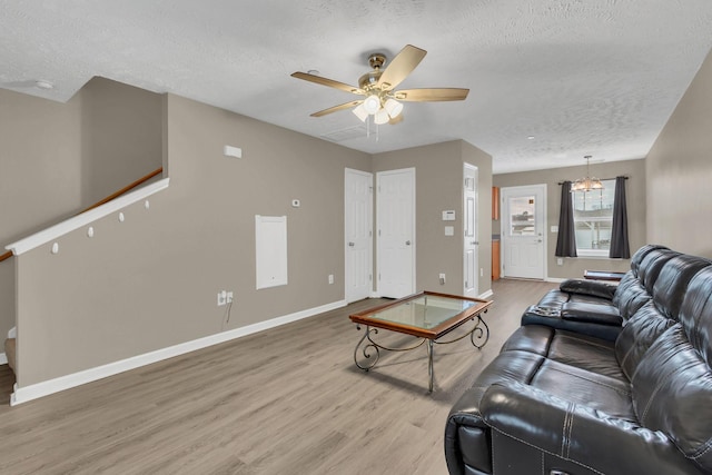 living room featuring a textured ceiling, hardwood / wood-style flooring, and ceiling fan