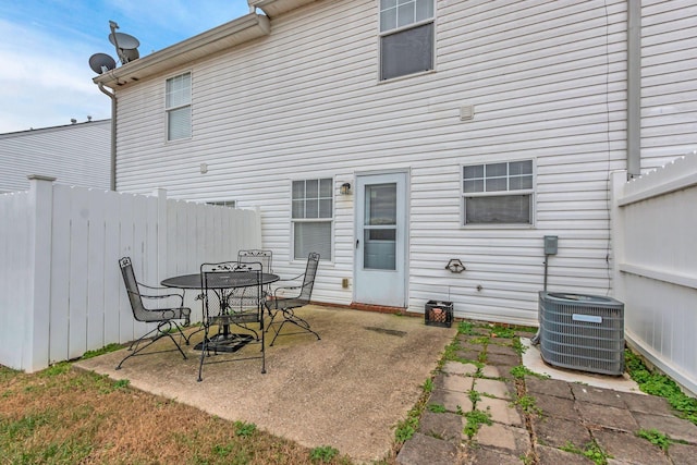 rear view of property featuring a patio and central air condition unit