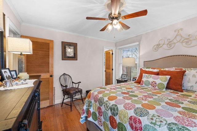 bedroom featuring hardwood / wood-style flooring, ceiling fan, and crown molding