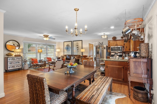 dining space with ceiling fan with notable chandelier, ornamental molding, and light hardwood / wood-style flooring