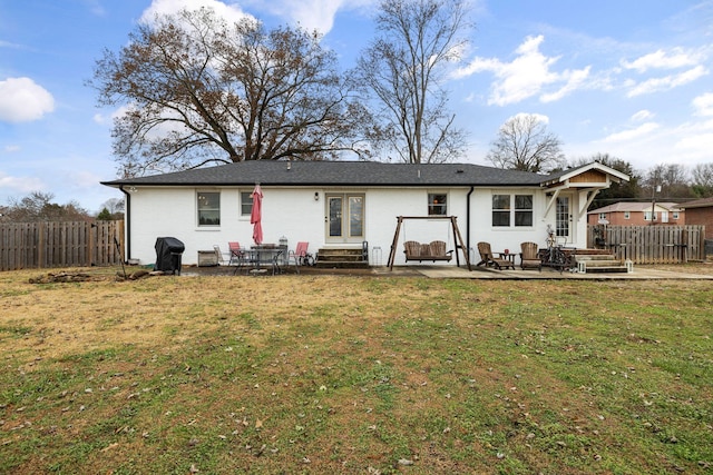 rear view of house featuring a patio and a lawn