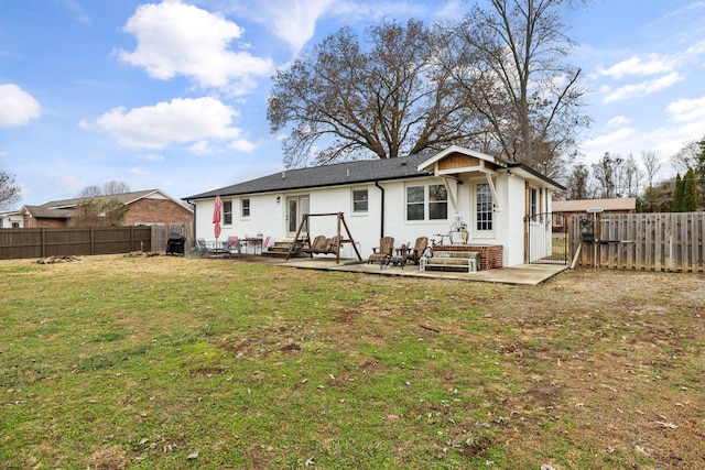 back of house with a lawn and a patio area