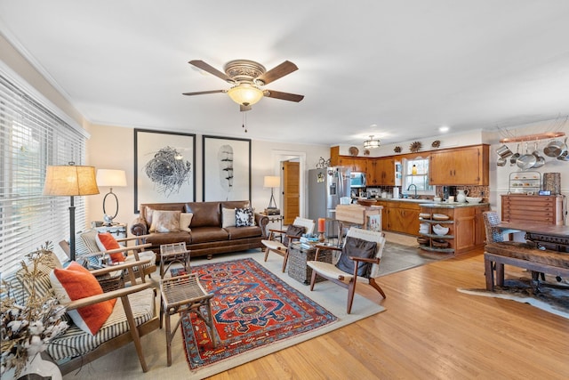 living room featuring a wealth of natural light, sink, ceiling fan, and light hardwood / wood-style floors