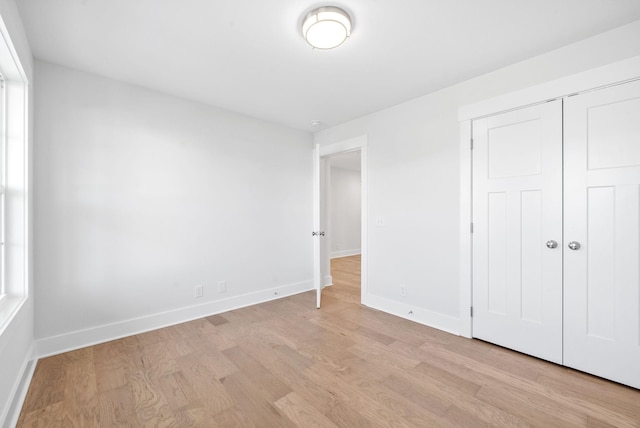 unfurnished bedroom with light hardwood / wood-style floors and a closet