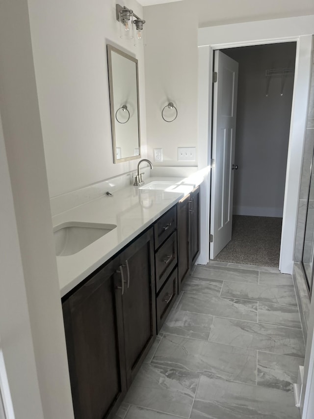 full bathroom featuring double vanity, marble finish floor, and a sink