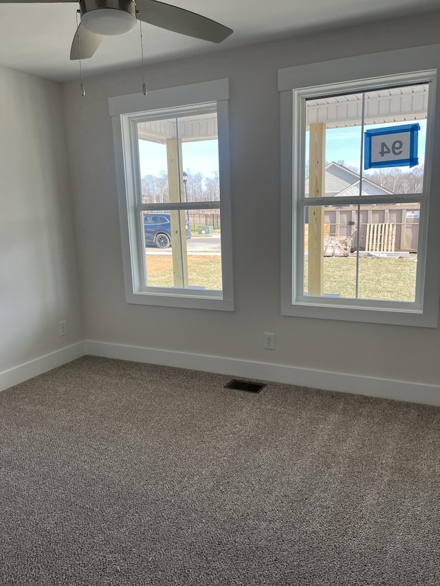 empty room with a ceiling fan, baseboards, and carpet floors