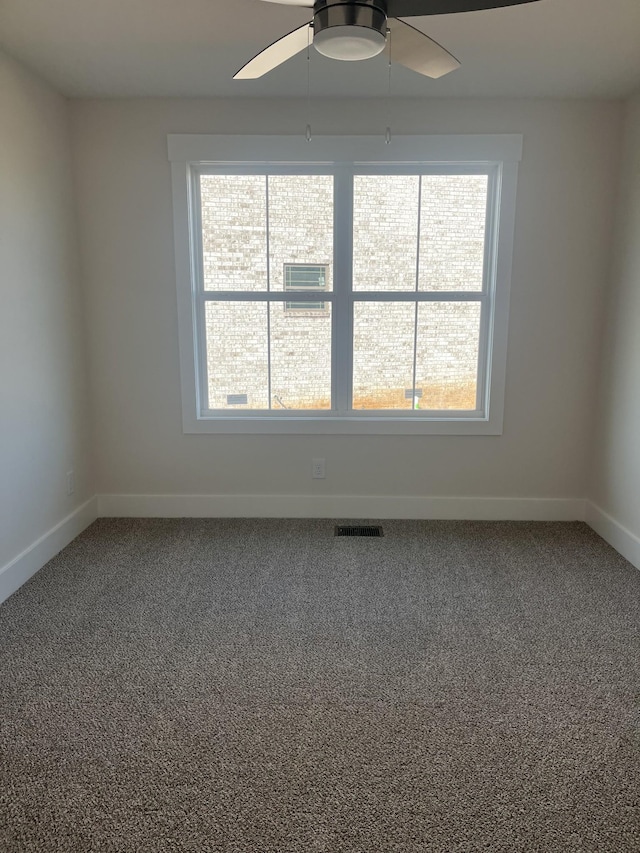 spare room with visible vents, a ceiling fan, baseboards, and carpet floors