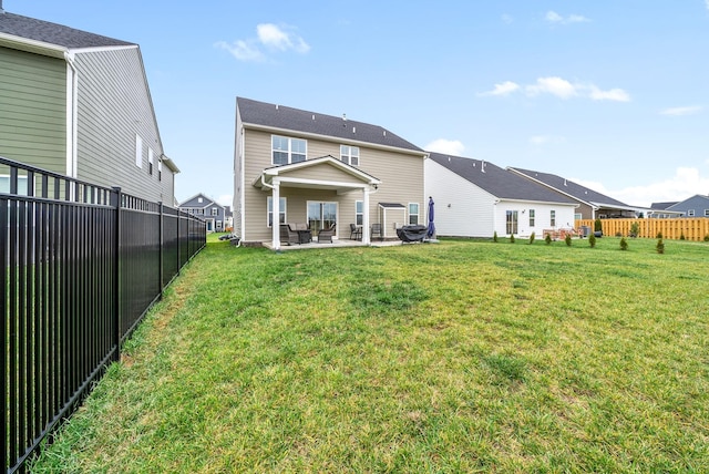 back of property with a yard and a patio