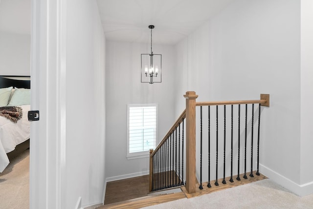 stairway with carpet and a notable chandelier