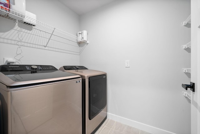 washroom with separate washer and dryer and light tile patterned flooring