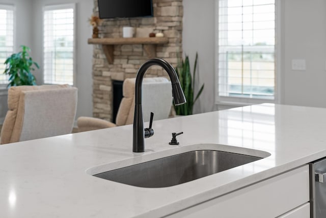 interior details featuring a stone fireplace and sink