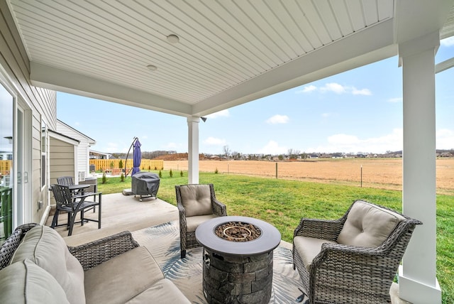 view of patio / terrace with a rural view and an outdoor living space with a fire pit