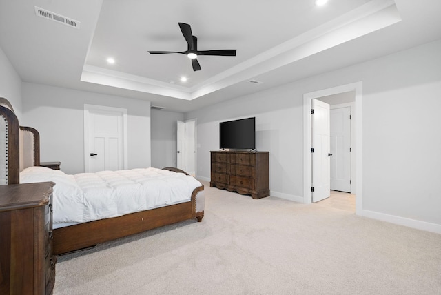 bedroom featuring ceiling fan, a raised ceiling, and light colored carpet