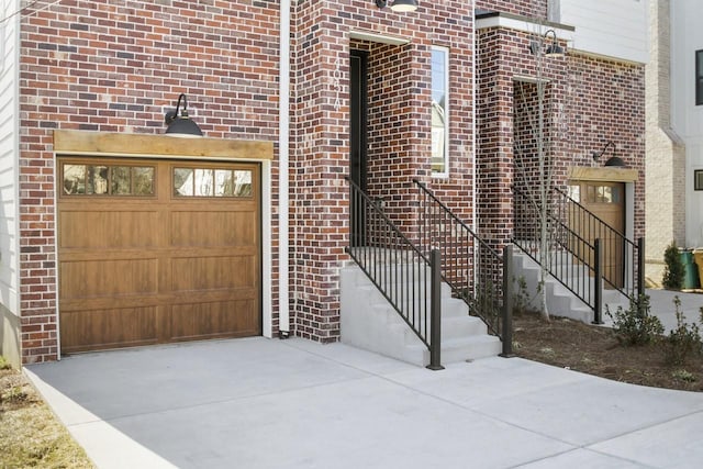 exterior space with a garage, concrete driveway, and brick siding