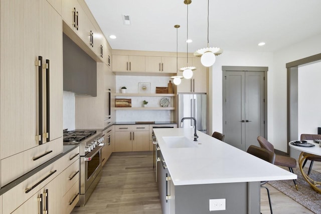 kitchen featuring pendant lighting, sink, a breakfast bar, a kitchen island with sink, and stainless steel appliances