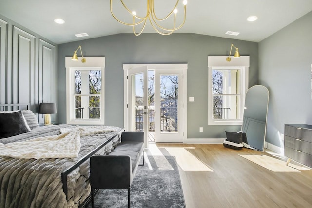 bedroom with multiple windows, lofted ceiling, and access to exterior