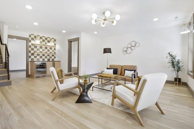 living room featuring light hardwood / wood-style flooring, beverage cooler, and indoor bar