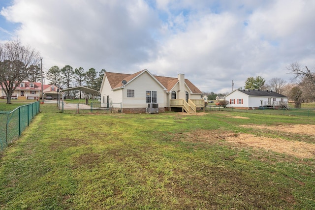 rear view of house with central AC, a wooden deck, and a lawn