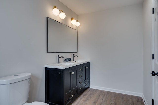 bathroom with vanity, hardwood / wood-style flooring, and toilet