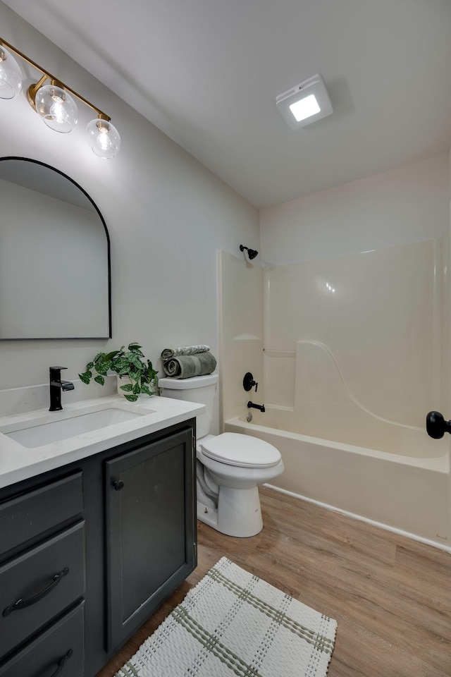 full bathroom featuring vanity,  shower combination, hardwood / wood-style flooring, and toilet