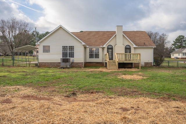 rear view of property featuring central AC, a carport, a wooden deck, and a lawn