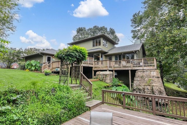 rear view of house with a lawn and a wooden deck