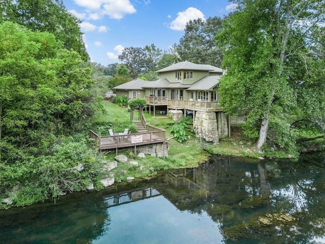 rear view of house featuring a deck with water view