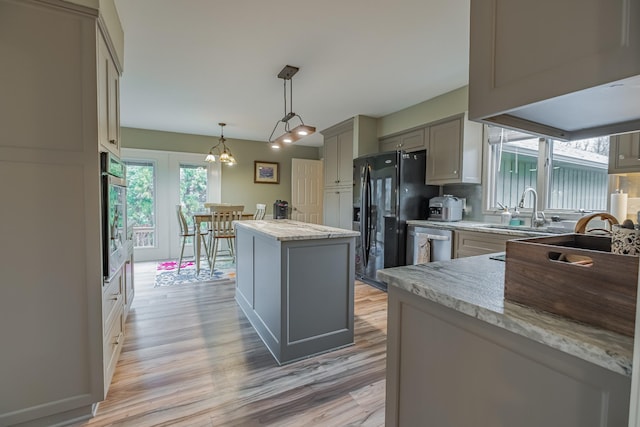 kitchen featuring decorative light fixtures, a kitchen island, plenty of natural light, and gray cabinetry