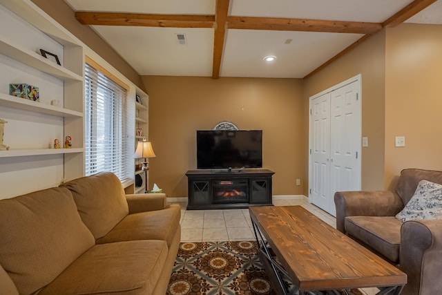 tiled living room with beamed ceiling, built in features, and a fireplace