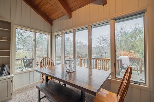 sunroom / solarium with lofted ceiling with beams, a wealth of natural light, and wood ceiling