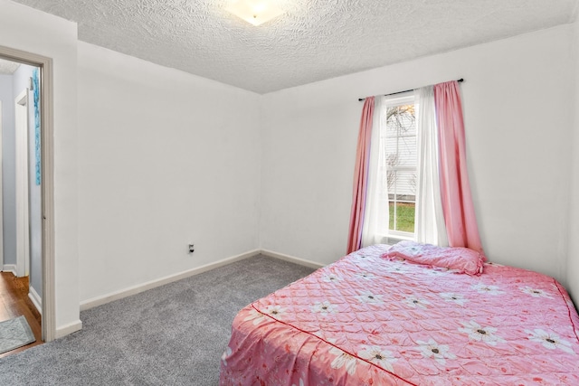 bedroom with dark colored carpet and a textured ceiling