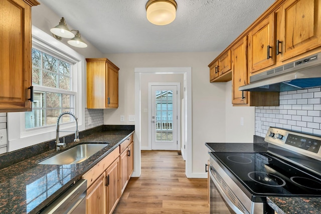 kitchen with tasteful backsplash, sink, dark stone counters, and appliances with stainless steel finishes