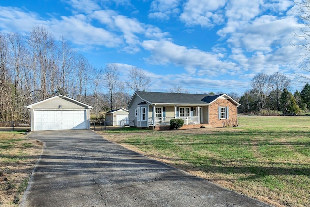 single story home with a porch, a garage, an outdoor structure, and a front yard