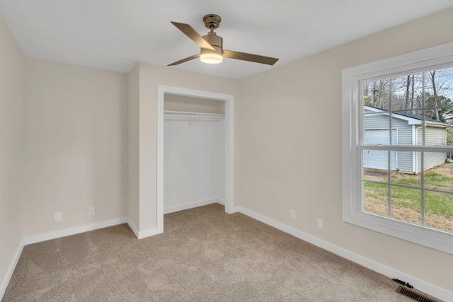 unfurnished bedroom featuring ceiling fan, light colored carpet, and a closet