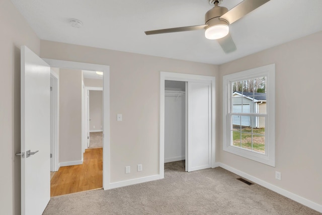 unfurnished bedroom with light carpet, a closet, and ceiling fan