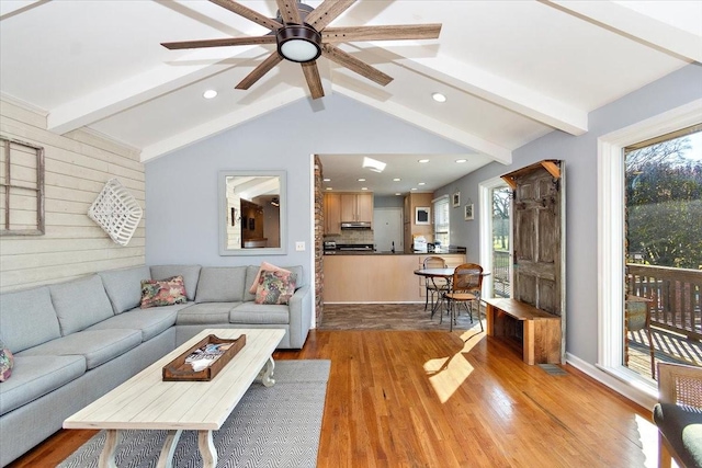 living room featuring ceiling fan, lofted ceiling with beams, and light wood-type flooring