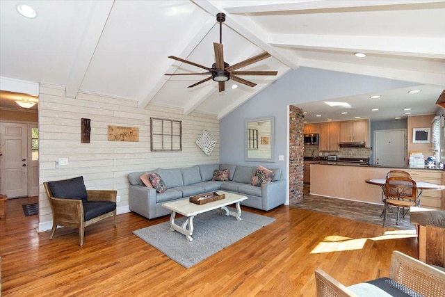 living room with vaulted ceiling with beams, light hardwood / wood-style flooring, and ceiling fan